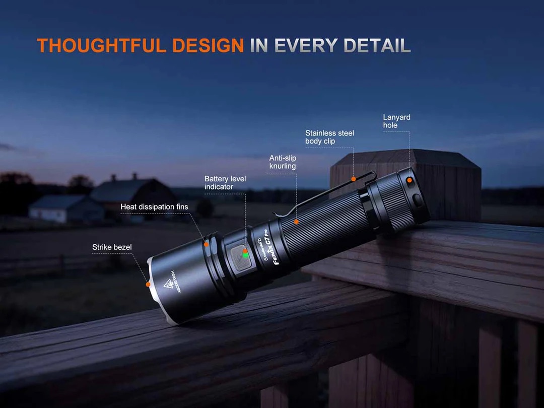 Flashlight angled on a railing with callouts highlighting design details: strike bezel, heat-dissipation fins, battery level indicator, anti-slip knurling, stainless steel body clip, and lanyard hole.