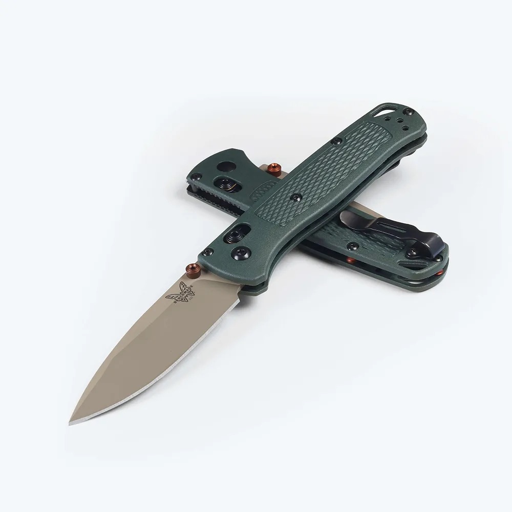 Green textured folding knife with an open tan blade on a light background, showing the handle and blade