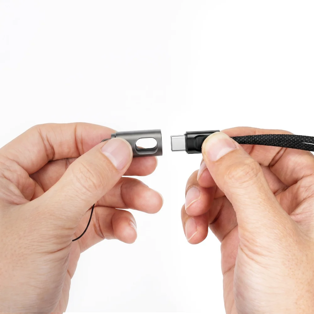 Close-up of hands separating a USB-C plug from its protective cap on a braided charging cable.
