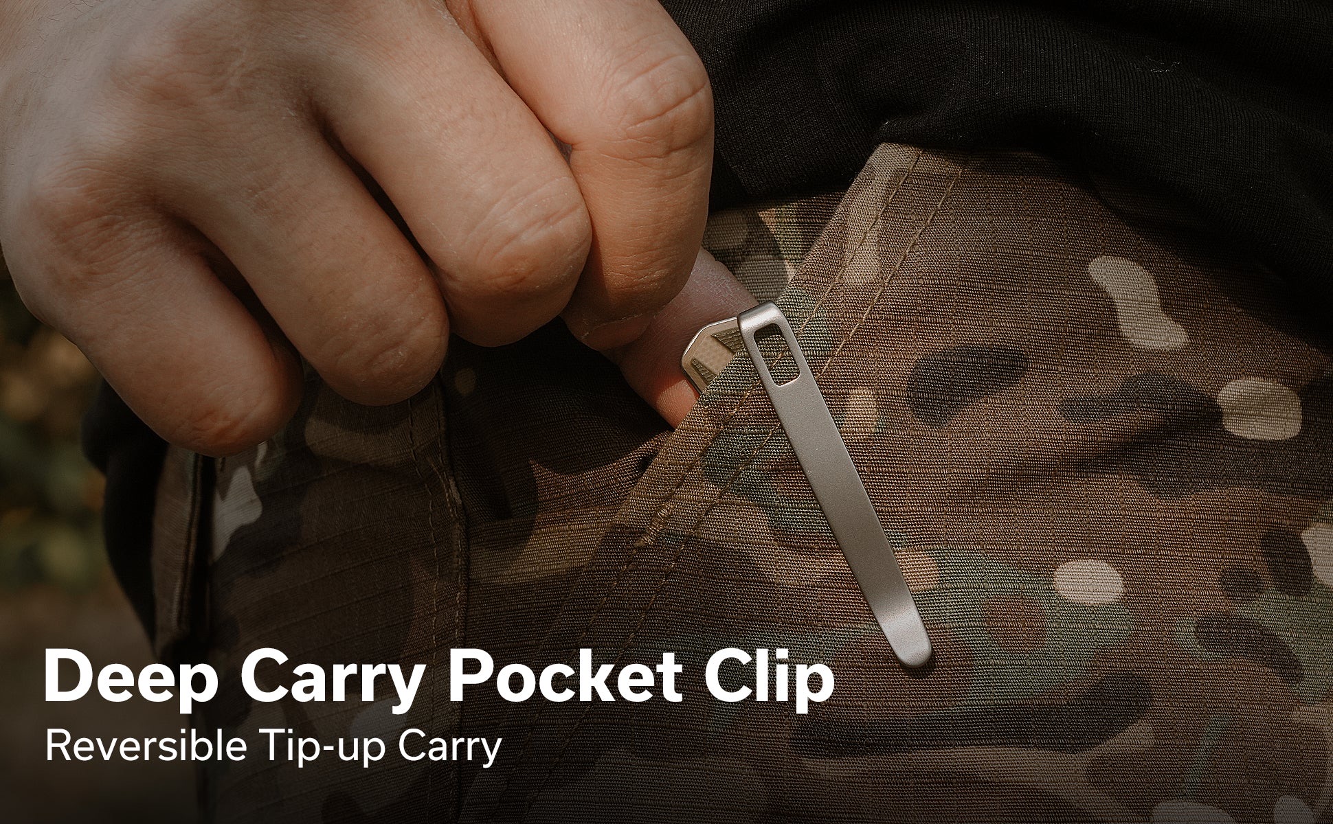 Close-up of a hand pulling a zipper tab on camouflage pocket fabric, showcasing a metal deep-carry clip design in use.