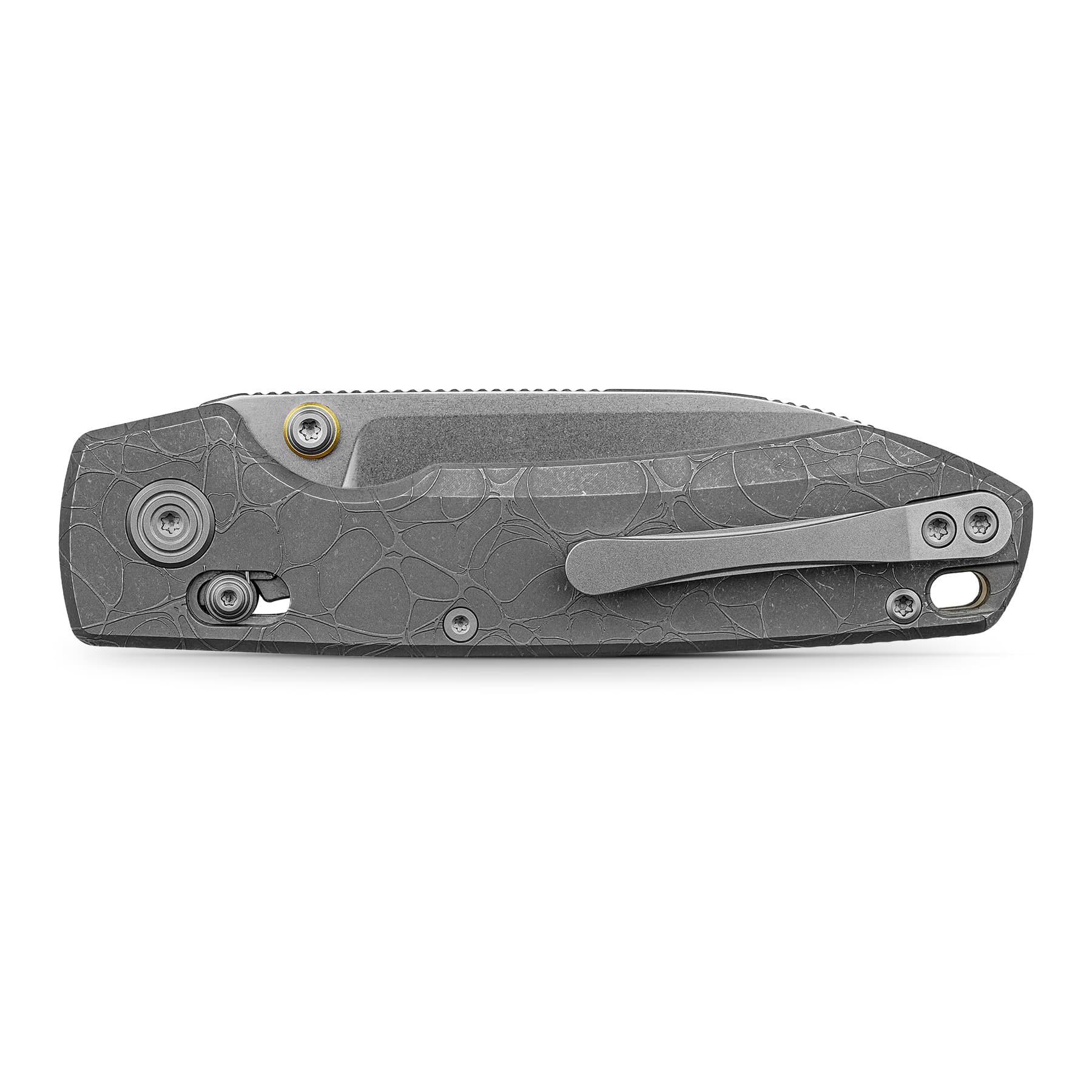 Close-up of a gray textured folding knife handle with screws and a pocket clip visible at the right edge