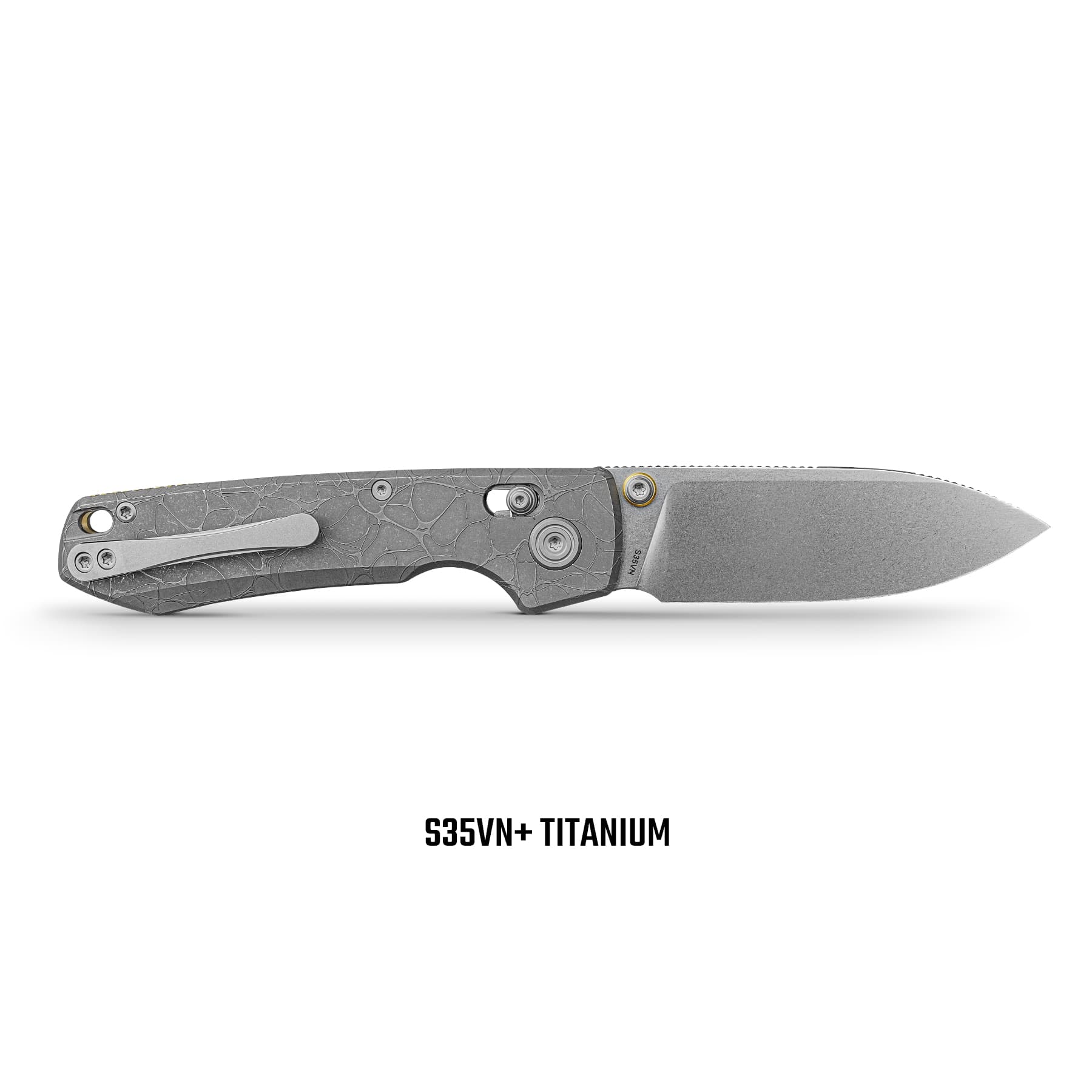 Close-up of a gray titanium folding knife blade with a textured pattern and visible screws, the text 'S35VN+ TITANIUM' shown beneath.