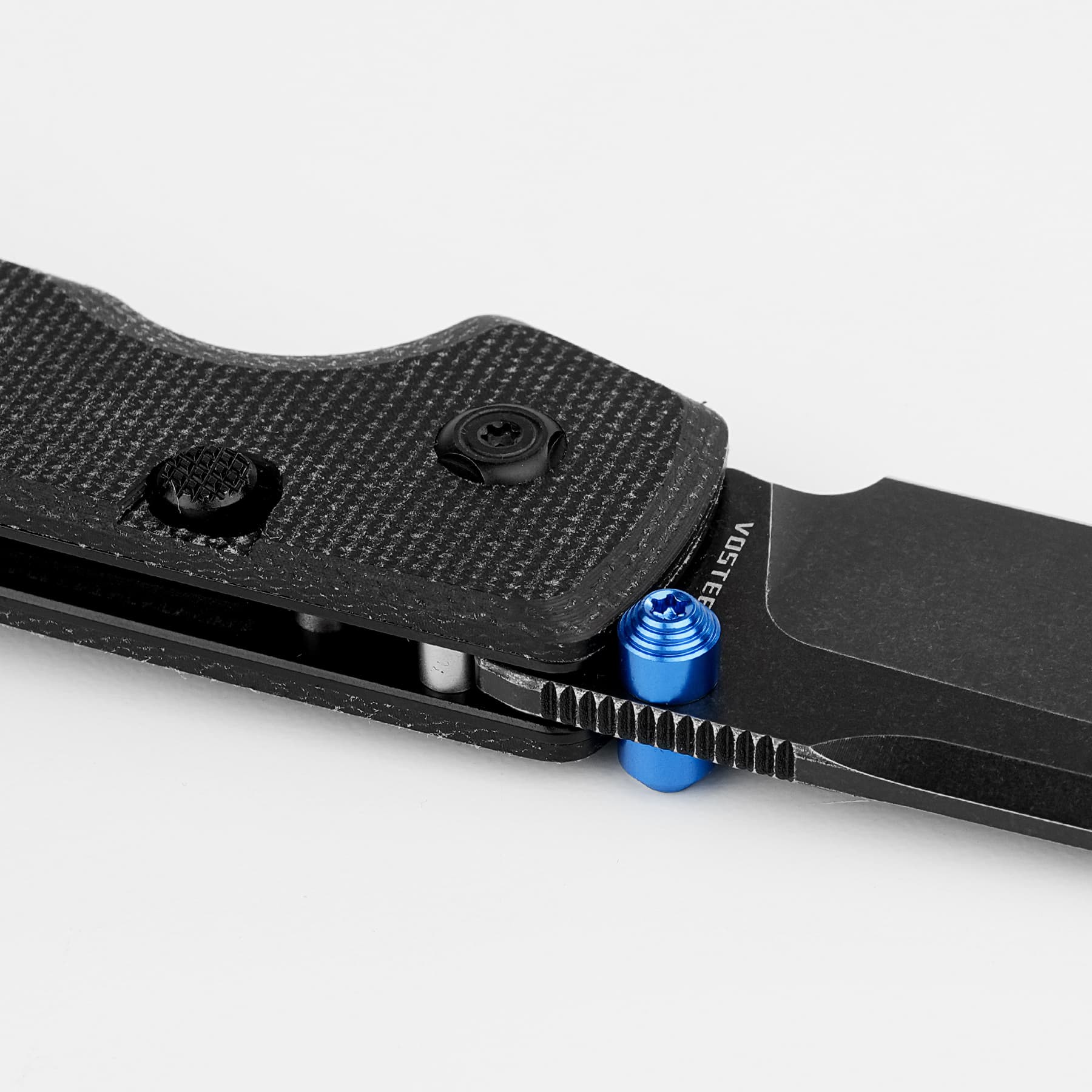Close-up of a black textured mounting plate with a round fastener and blue adjustment knobs on a dark base piece of equipment, shown in profile.