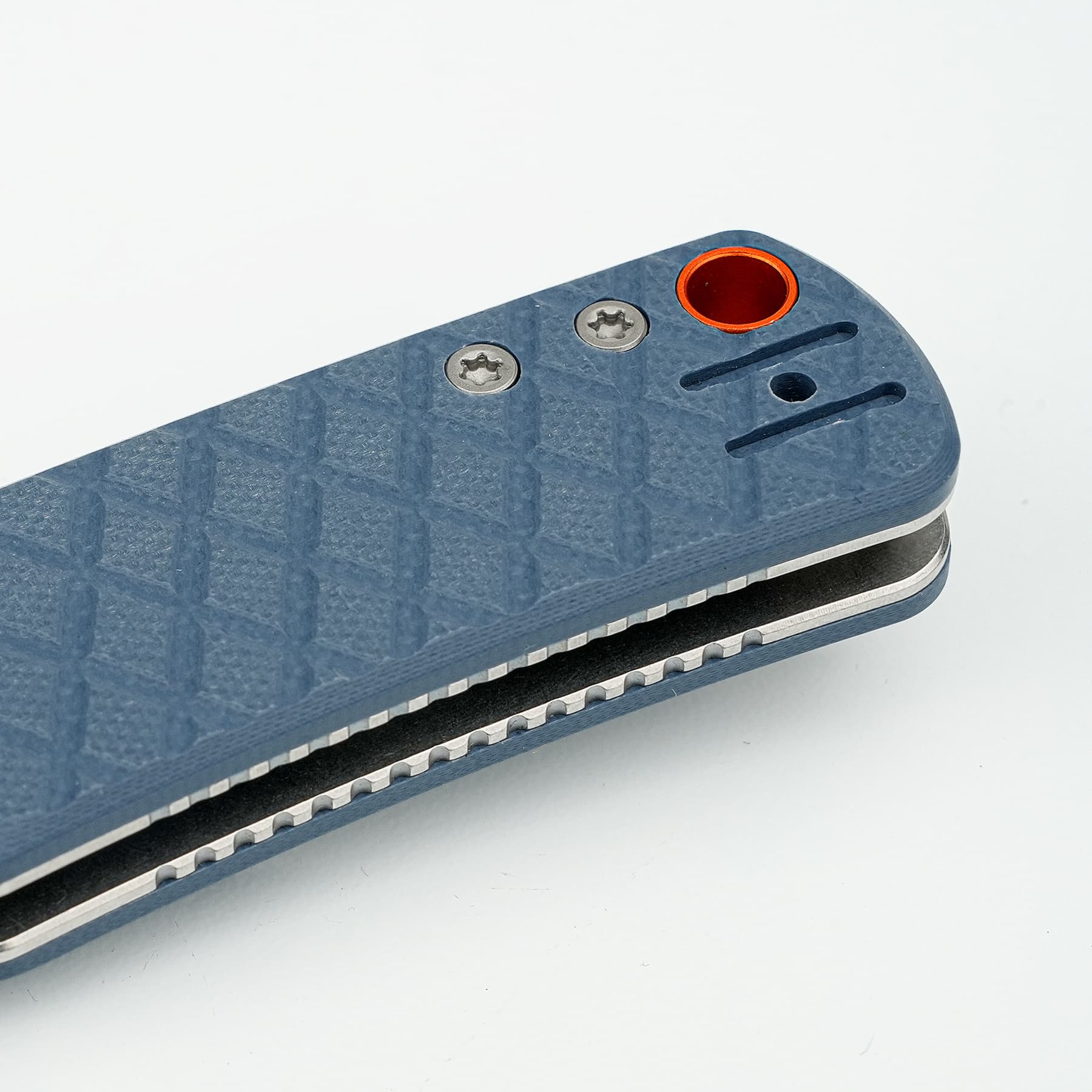 Close-up of a blue textured handheld tool corner with two screws and an orange circular opening over a blade slot.