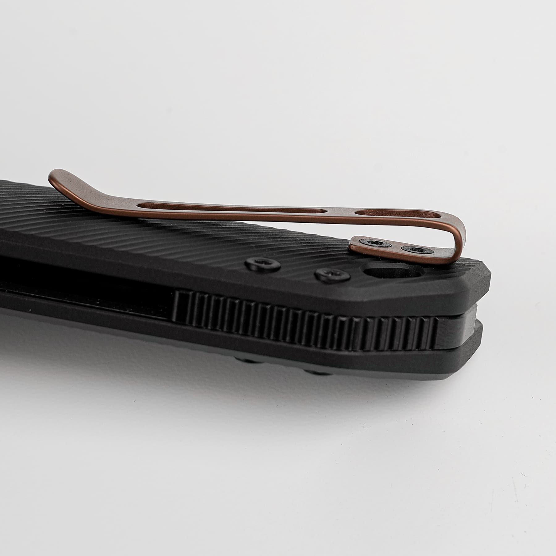 Copper-colored metal clip resting on a black textured keyboard surface.