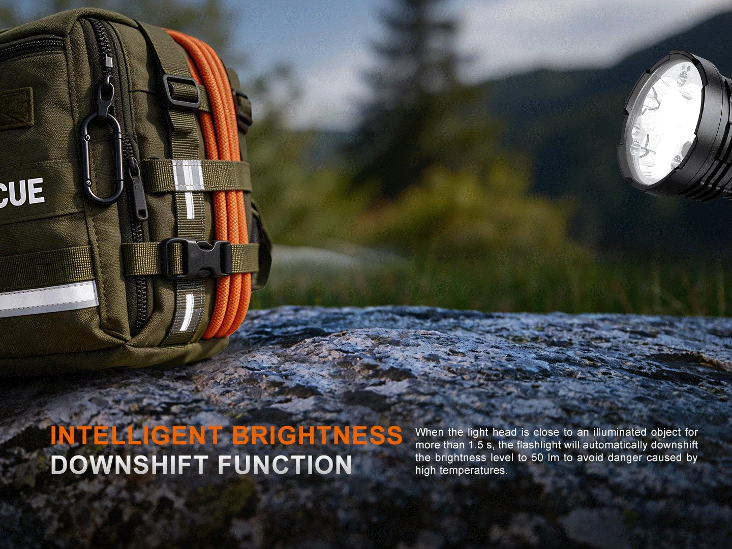 Close-up of an olive tactical backpack with orange rope and a carabiner beside a large flashlight on a rock outdoors, suggesting rescue gear.