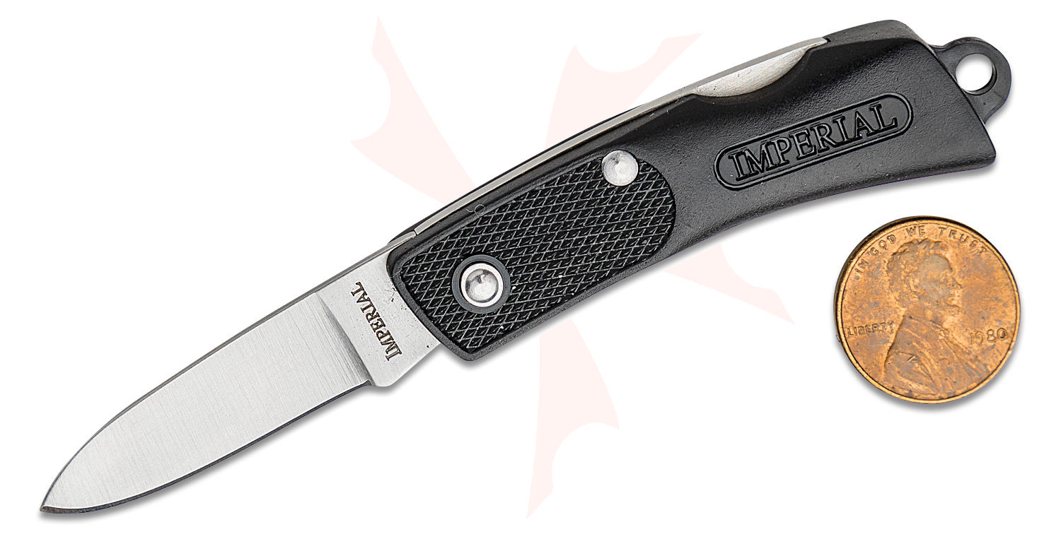 Open folding knife by Imperial with a black textured grip, blade extended, shown beside a Lincoln penny for scale.